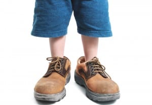 kid in big shoes on white background