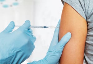 Nurse makes vaccination in the shoulder of patient in a clinic