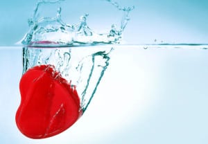 red heart sinking in water closeup
