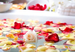 Rose with flower petals in a spa bathtub