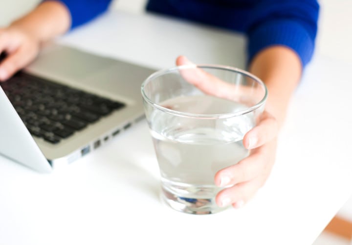 Drinking water while working with laptop computer