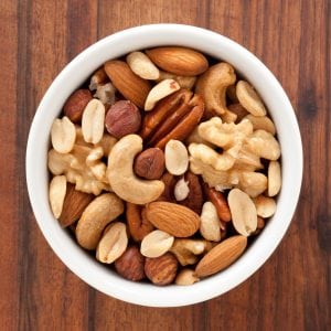 Top view of white bowl full of variety of nuts