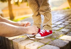 Father tying sons's shoes