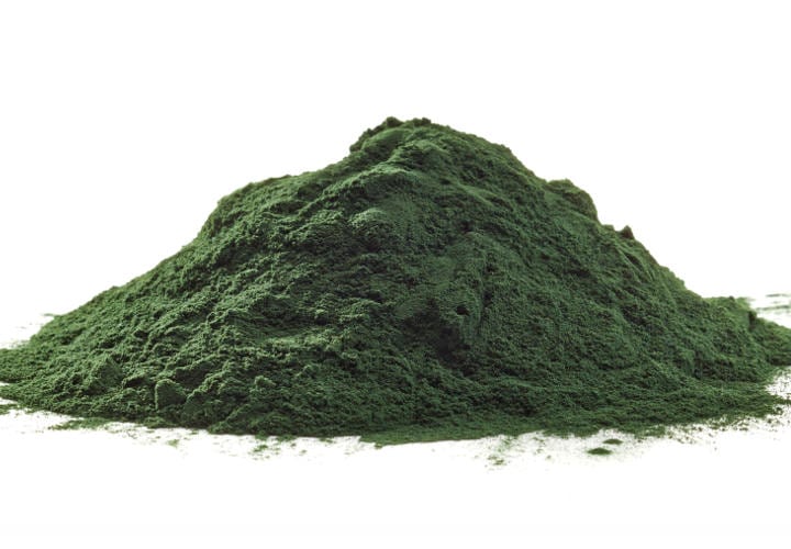 Stack of spirulina algae powder isolated on white background